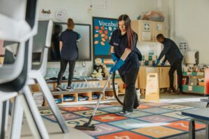 Cleaner in a refurbished classroom with blackboard and desks